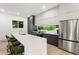Modern kitchen with an island, stylish stools, stainless steel appliances, and large picture window at 833 Humphries Sw St, Atlanta, GA 30310