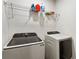 Functional laundry room featuring modern washer and dryer units and shelving with cleaning supplies at 833 Humphries Sw St, Atlanta, GA 30310