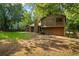 Exterior view of a two-story home with wood siding, concrete patio, and green grass backyard at 340 Windsor Se Walk, Conyers, GA 30094