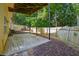 A charming covered back patio with a concrete floor, wood fence, and surrounding trees at 1343 Cartwright Ln, Lawrenceville, GA 30045