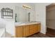 Bathroom featuring a double vanity, decorative mirror, wood cabinets, and access to the walk-in closet at 1343 Cartwright Ln, Lawrenceville, GA 30045