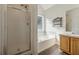 This bathroom features a large soaking tub, walk-in shower, and wood look floors at 1343 Cartwright Ln, Lawrenceville, GA 30045
