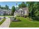 View of home's manicured lawn, brick exterior, and lush, mature landscaping at 1343 Cartwright Ln, Lawrenceville, GA 30045