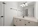 Bright bathroom featuring a white vanity with a mirror, dark fixtures, and a door to the hallway at 1805 Wilkenson Xing, Marietta, GA 30066