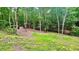 Lush green backyard with mature trees and distant storage shed, perfect for outdoor activities at 7460 Highway 101, Rockmart, GA 30153