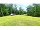 Expansive view of the lush green backyard with mature trees and a shed in the distance at 7460 Highway 101, Rockmart, GA 30153