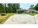 Property features a covered parking area adjacent to the house, with a spacious paved driveway and lush green lawns at 7460 Highway 101, Rockmart, GA 30153
