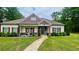 Charming single-story home featuring a well-manicured lawn, decorative shutters, and a welcoming front porch with stone accents at 7460 Highway 101, Rockmart, GA 30153