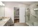 Modern bath with tiled shower and gray vanity, showcasing an open view to the main bedroom at 1024 Brownstone Dr # 2, Marietta, GA 30008
