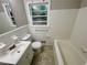 Bright bathroom featuring a white tub, toilet, vanity and a window view of the backyard at 25 Gladstone Sw Dr, Marietta, GA 30060