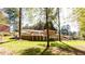Lush green backyard featuring a brick home with a large deck, perfect for outdoor entertaining and relaxation at 504 Milligan Dr, Stone Mountain, GA 30083