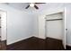 Bedroom features dark hardwood floors, neutral walls and an open closet for ample storage at 504 Milligan Dr, Stone Mountain, GA 30083