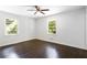 Bright bedroom features hardwood floors, modern ceiling fan, and double windows overlooking a lush landscape at 504 Milligan Dr, Stone Mountain, GA 30083