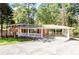 Charming brick home with a covered carport and inviting front porch, showcasing classic architecture and curb appeal at 504 Milligan Dr, Stone Mountain, GA 30083