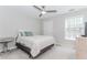 A bedroom with a ceiling fan features a window and has a round table for a lamp at 2373 Oak Falls Ln, Buford, GA 30519