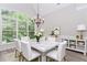 Elegant dining room featuring a marble table, chandelier, and a large window with a view at 2373 Oak Falls Ln, Buford, GA 30519