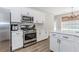 Bright kitchen features white cabinets, stainless steel appliances, and granite countertops at 2373 Oak Falls Ln, Buford, GA 30519