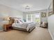 Bedroom features a tufted headboard bed, bedside table, and natural light from multiple windows at 4004 Charrwood Trce, Marietta, GA 30062