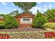 Charming neighborhood entrance sign with brick architecture, lush greenery, and vibrant flower beds at 4004 Charrwood Trce, Marietta, GA 30062