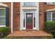 Elegant brick home entrance showcasing a decorative glass door, sidelights, and classic sconces at 4004 Charrwood Trce, Marietta, GA 30062