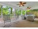 Inviting covered porch with rocking chairs, wicker seating, and ceiling fans, perfect for relaxing outdoors at 4004 Charrwood Trce, Marietta, GA 30062