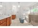 This bathroom features dual vanities, walk-in shower, and soaking tub at 625 St Annes Pl, Covington, GA 30016