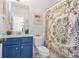 Colorful bathroom with a blue vanity, decorative shower curtain, and a mirror at 625 St Annes Pl, Covington, GA 30016