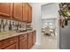 Butler's pantry with decorative wallpaper, granite countertops, and dining room view at 625 St Annes Pl, Covington, GA 30016