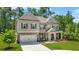 Beautiful two-story home with a mix of brick and siding, a two-car garage, and lush landscaping at 625 St Annes Pl, Covington, GA 30016