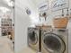 A laundry room next to a closet, with a modern washer and dryer at 625 St Annes Pl, Covington, GA 30016