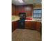 Traditional kitchen features wood cabinets, laminate countertops, and black appliances at 1034 Bettina Sw Ct, Mableton, GA 30126