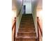 Carpeted staircase leading upstairs with a wooden railing and light-colored walls at 1034 Bettina Sw Ct, Mableton, GA 30126