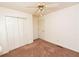 Cozy bedroom with neutral walls, carpet, ceiling fan, and double door closet at 7030 Wessex Way, Cumming, GA 30028