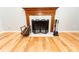 Close-up of the fireplace featuring a wooden mantle, marble surround, and hardwood floors at 7030 Wessex Way, Cumming, GA 30028