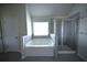 Bathroom with a tub, separate glass shower, and tiled accents at 2504 Bear Mountain St, Lithonia, GA 30058