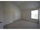 Neutral bedroom showcasing a window, vaulted ceiling, plush carpet and double-door closet at 2504 Bear Mountain St, Lithonia, GA 30058