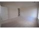Bright bedroom featuring neutral carpet and paint, with a door and a glimpse into the hallway at 2504 Bear Mountain St, Lithonia, GA 30058