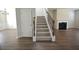 View of the living room with fireplace, hardwood flooring, and stairs to the second level at 2504 Bear Mountain St, Lithonia, GA 30058