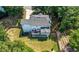 Aerial view of a home with a large yard, deck, and mature trees at 312 Laurel Run Cv, Sugar Hill, GA 30518