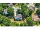 Aerial view of home with fenced backyard and lush landscaping on a tree-lined street at 312 Laurel Run Cv, Sugar Hill, GA 30518
