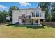 Spacious backyard with a patio, deck, well-maintained lawn and lush greenery at 312 Laurel Run Cv, Sugar Hill, GA 30518