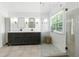 Bright bathroom featuring a double vanity, quartz countertop, shower, and a window for natural light at 312 Laurel Run Cv, Sugar Hill, GA 30518