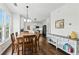 Cozy dining area with wood table, pendant lighting, and view into modern kitchen at 312 Laurel Run Cv, Sugar Hill, GA 30518