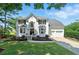 Charming white two-story home with a well-manicured lawn and attached two car garage at 312 Laurel Run Cv, Sugar Hill, GA 30518