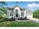 Charming two-story white home with black shutters and landscaped front yard, plus two-car garage at 312 Laurel Run Cv, Sugar Hill, GA 30518
