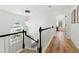 Upstairs hallway with hardwood floors, modern chandelier, and lots of natural light at 312 Laurel Run Cv, Sugar Hill, GA 30518