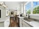 Open concept kitchen with white cabinetry, stainless appliances, and view into the living room at 312 Laurel Run Cv, Sugar Hill, GA 30518