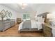 Main bedroom features modern decor, tray ceilings, hardwood floors, and lots of natural light at 312 Laurel Run Cv, Sugar Hill, GA 30518