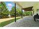 Covered patio with stone flooring, black pillars, and outdoor seating area at 312 Laurel Run Cv, Sugar Hill, GA 30518