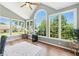 Bright sunroom with arched windows offering scenic outdoor views and hardwood flooring at 312 Laurel Run Cv, Sugar Hill, GA 30518